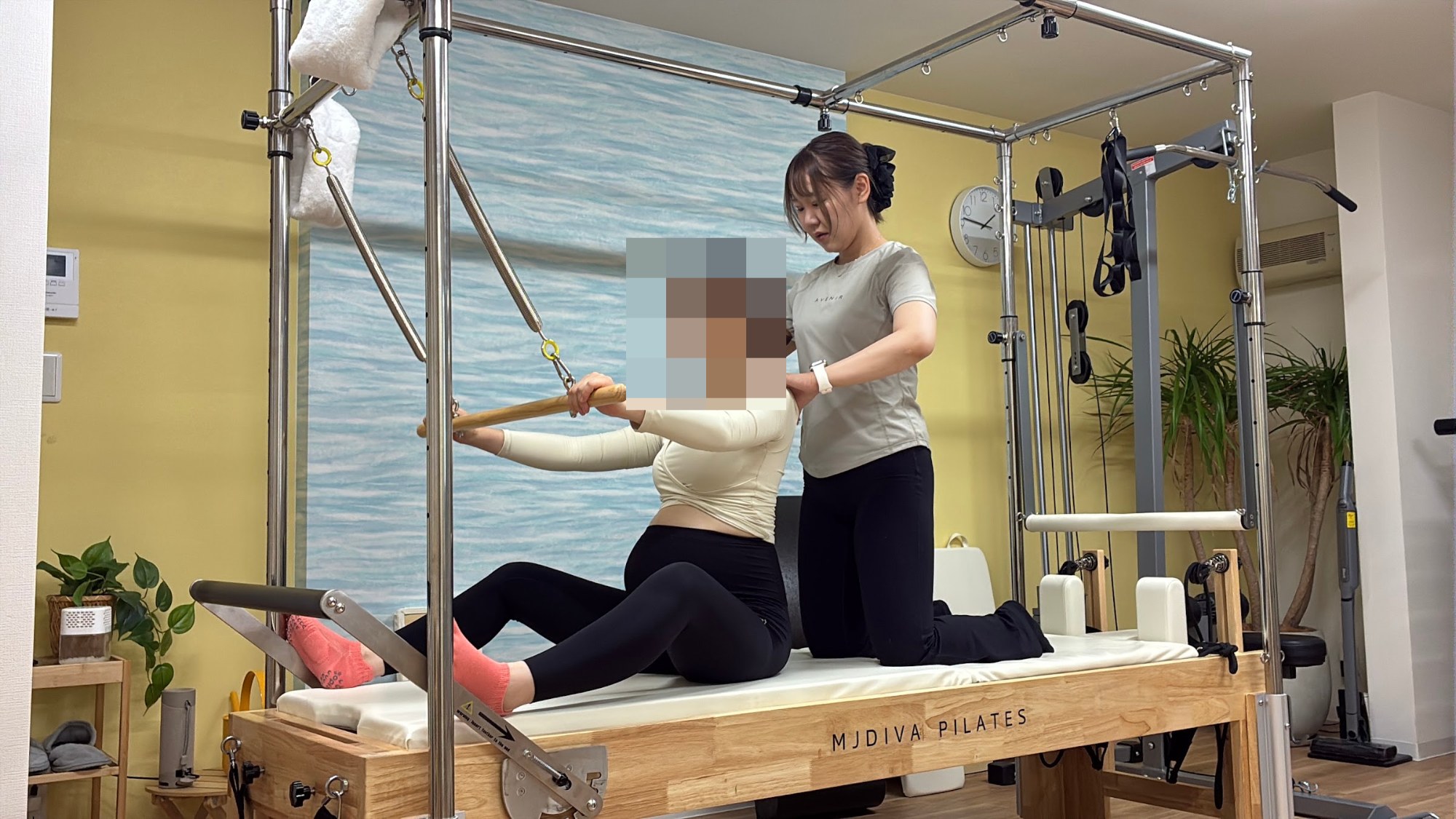 マタニティピラティス:マシン(キャデラック)で体を動かす妊娠中の方と、補助するトレーナー